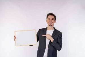 Portrait of happy businessman showing blank signboard on isolated white background photo