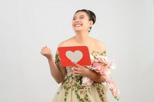 Asian beautiful bride smiling and posing with heart sign on white background photo