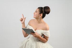 Young asian beautiful bride pose with tablet in hand photo