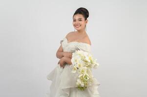 Young asian beautiful bride with orchid bouquet on white background photo