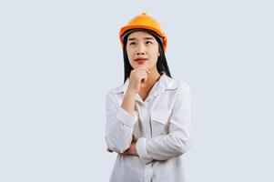 Young female engineer in helmet stand with thoughtful posture photo