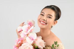 Young asian beautiful bride with orchid bouquet on white background photo