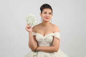 Young asian beautiful bride holding dollar bills in hand photo