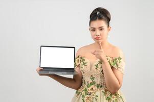 Young asian beautiful bride pose with mock up laptop computer in hand photo