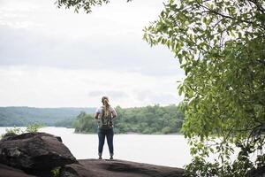 close up back of tourist girl happy with nature near lake photo