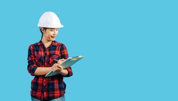 Young asian engineer female use pen to check list on clipboard posture photo