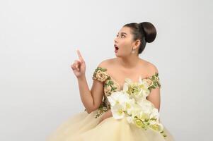 Young asian beautiful bride with orchid bouquet on white background photo