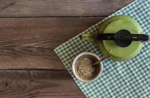 mate and kettle, traditional Argentine yerba mate infusion, on rustic wooden background photo