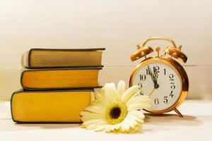 clock flowers and books concept of spring time and reading photo