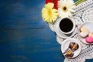 romantic flowers with coffee and sweet treats on the table photo