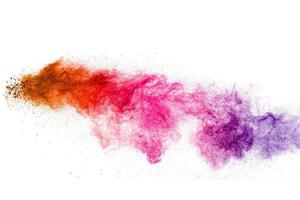 explosión de polvo multicolor sobre fondo blanco. lanzó salpicaduras de partículas de polvo de colores. foto
