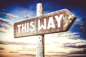 This Way - Wooden Signpost with one Arrow, Sunset Sky in Background photo