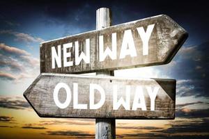 New Way, Old Way - Wooden Signpost with Two Arrows, Sunset Sky in Background photo