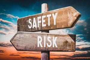 Risk, Safety - Wooden Signpost with Two Arrows, Sunset Sky in Background photo