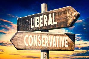 Liberal, Conservative - Wooden Signpost with Two Arrows, Sunset Sky in Background photo