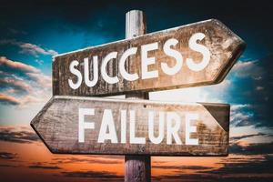 Success, Failure - Wooden Signpost with Two Arrows, Sunset Sky in Background photo