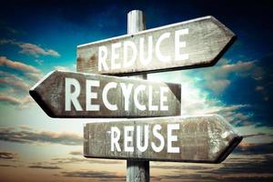 Reduce, Recycle, Reuse - Wooden Signpost with Three Arrows, Sunset Sky in Background photo