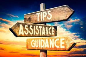 Tips, Assistance, Guidance - Wooden Signpost with Three Arrows, Sunset Sky in Background photo