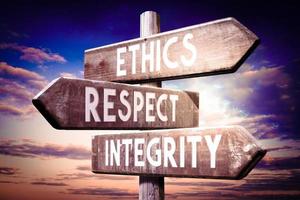 Ethics, Respect, integrity - Wooden Signpost with Three Arrows, Sunset Sky in Background photo