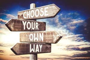 Choose Your Own Way - Wooden Signpost with Four Arrows, Sunset Sky in Background photo