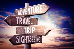 Adventure, Travel, Trip, Sightseeing - Wooden Signpost with Four Arrows, Sunset Sky in Background photo