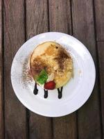 Pancake with sweetened condensed milk on Wooden Table photo