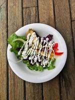 Salad With Mayonnaise Sauce on Wooden Table photo