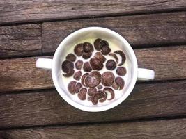 A bowl of cereal chocolate flavor with milk for breakfast photo