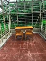 Wooden table and wooden seating on brownish-red ceramics photo