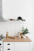 Bright kitchen in the Scandinavian style. Pasta in a glass jar, houseplant, glasses and kitchen utensils photo