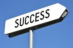 Success - White, Metal Signpost and Sky in Background photo