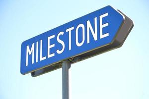 Milestone - Blue Metal Signpost and Sky in Background photo