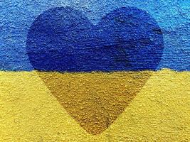 heart on Ukrainian flag painted on stone wall photo