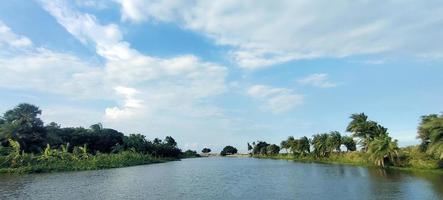 Blue sky and  the river beach with a green tree blue sky electric tower  in the background photo