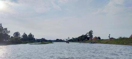 Blue sky and  the river beach with a green tree blue sky electric tower  in the background, natural view wallpaper photo