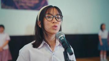 un alto colegio estudiante recita un poema en frente de el jueces mientras participativo en un competencia video