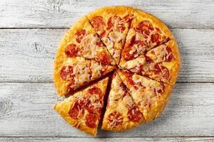 Tasty hot homemade pepperoni pizza. Traditional classic pizza with salami and cheese. Top view with copy space for text. photo