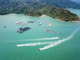 Fishing boats move near fishing farm photo