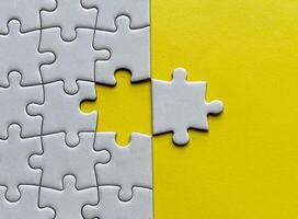 Top view of missing jigsaw puzzle with customizable space for text on yellow color background. Copy space. photo