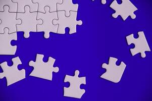 Top view of missing jigsaw puzzle on blue cover background. Copy space. photo