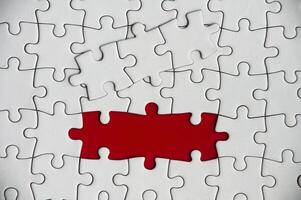 Top view of missing jigsaw puzzle on red cover background. Copy space photo