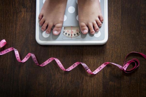 Lose weight concept. Bathroom scale, measuring tape, apples on wooden  background top view copyspace - Mile High Spine & Pain Center