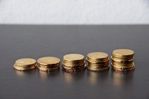 dorado monedas apilar en de madera mesa - crecimiento concepto foto
