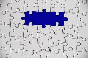 Top view of missing jigsaw puzzle on blue cover background. Copy space concept photo