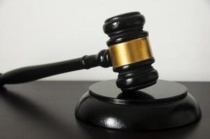 Straight view of lawyer gavel on wooden table with white background. photo