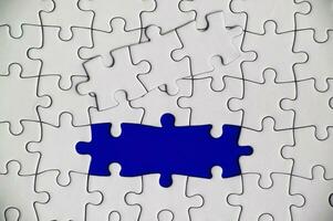 Top view of missing jigsaw puzzle on blue cover background. Copy space concept