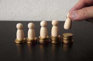 Coins Stack with wooden doll model and finger background - Business Concept photo