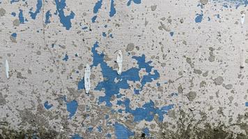 abstract texture background of an aged blue concrete wall with peeling paint photo