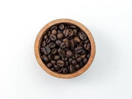 top view of coffee beans in wooden bowl isolated on white photo