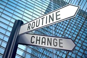 Change and Routine - Signpost With Two Arrows, Office Building in Background photo
